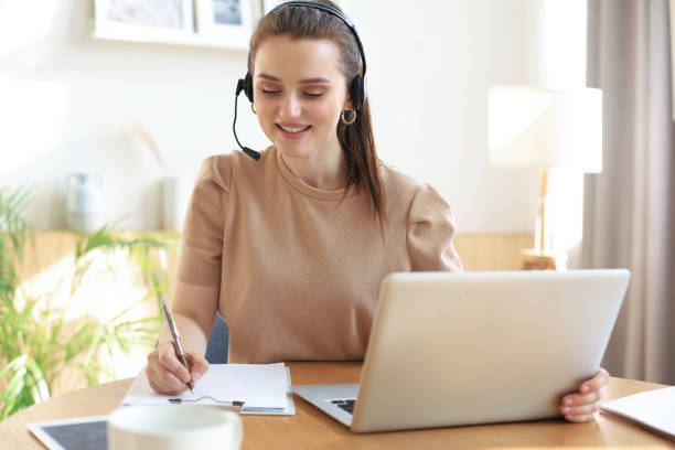 istock Freelance operator talking with headsets and consulting clients from home office. 1298344741