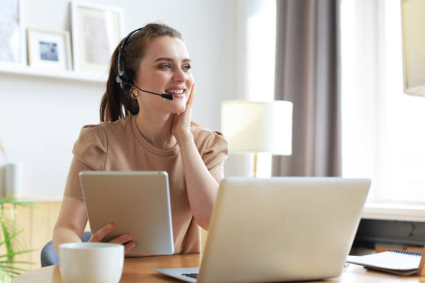 istock Freelance operator talking with headsets and consulting clients from home office. 1298346450