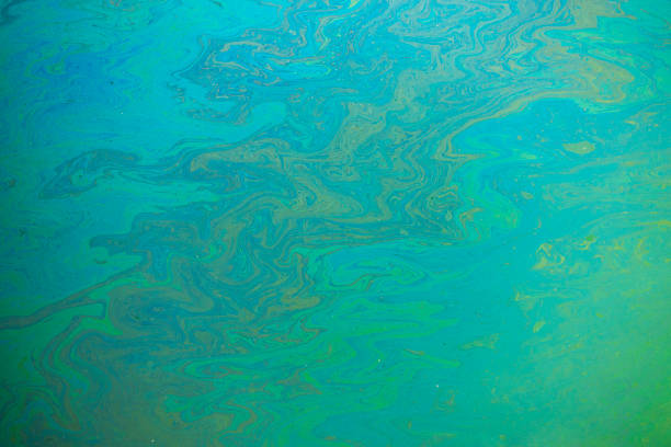 combustível de óleo da indústria liso derramando poluição da água - oil slick pouring chemical oil - fotografias e filmes do acervo