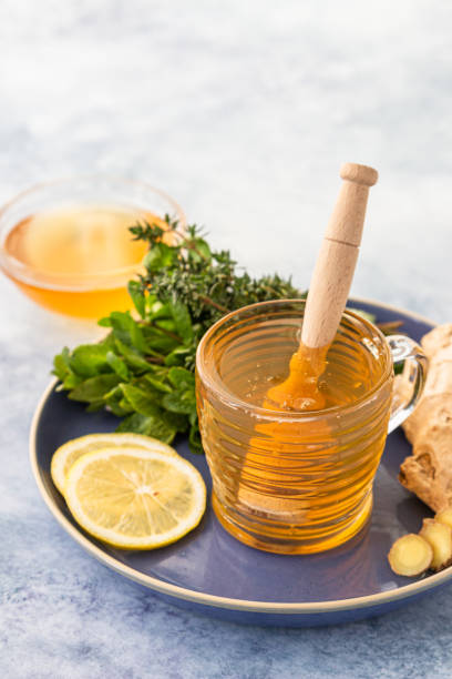 istock A cup of fresh herbal tea with thyme, mint, ginger, lemon and honey on blue concrete background. 1298348270