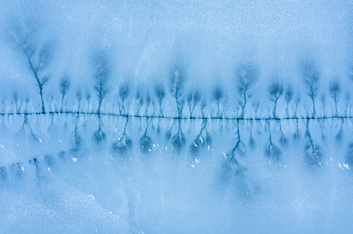 Large crack in the ice surface of a frozen lake. Aerial top view.