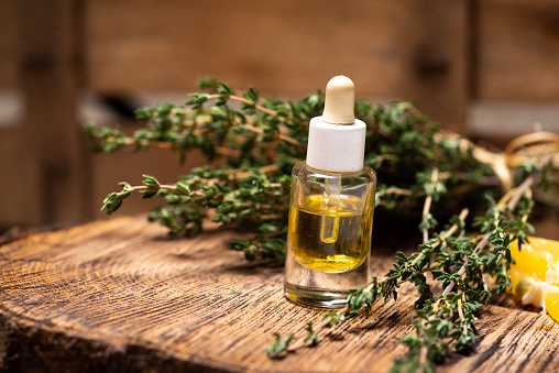 Fresh garden Thyme essential oil and herb on a rustic table