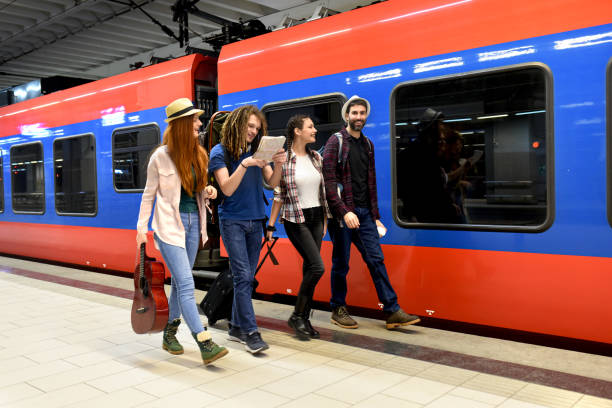 istock Few friends at the train station while waiting for a train for a long journey 1298349751