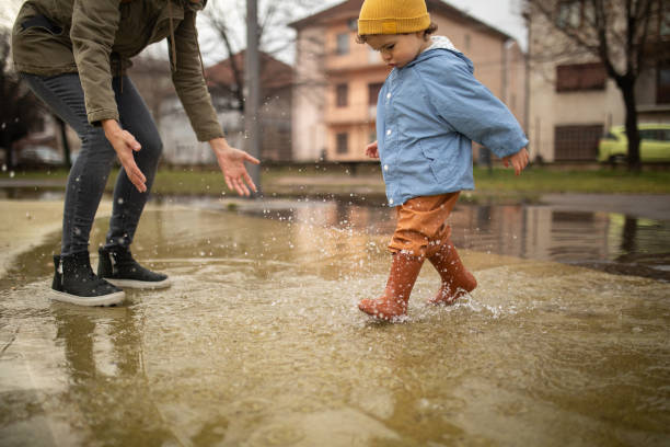 istock Mother having fun with her son in puddle on autumn day 1298349762