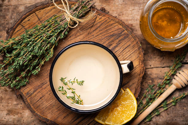 Garden thyme tea with fresh thyme leaves bunch on rustic table