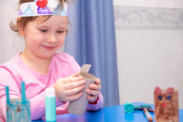 dětská předškoláková dívka ve věku 5 let, zabývá se uměním, vyrábí řemesla z lepenky a papíru. dětská představivost a kreativita doma. - ručně barvený fotky - stock snímky, obrázky a fotky