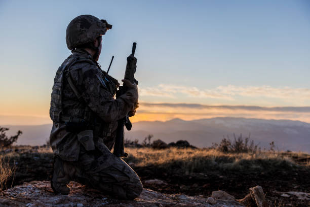 Female Army Solider watching sunset sky in battlefield