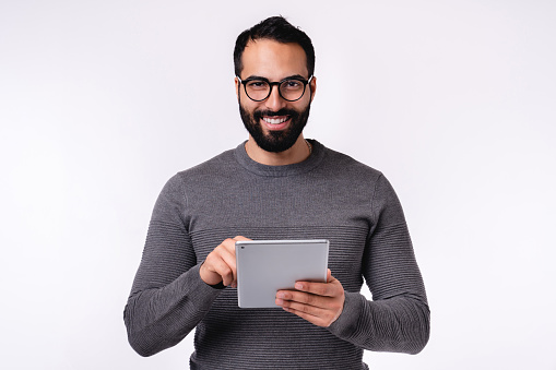 Middle East man in casual clothes using tablet isolated over white background