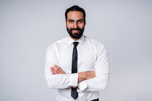 Successful 25s Middle East businessman in formal shirt isolated over grey background