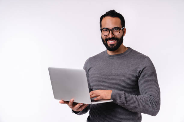 istock Happy confident young Middle East man using laptop isolated over white background 1298355197