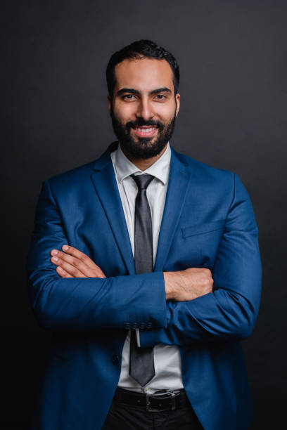 istock Confident middle eastern businessman in suit isolated over black background. Vertical shot 1298355519