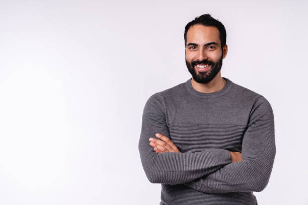 jeune homme arabe de sourire confiant dans des vêtements occasionnels d’isolement au-dessus du fond blanc - middle eastern ethnicity photos et images de collection
