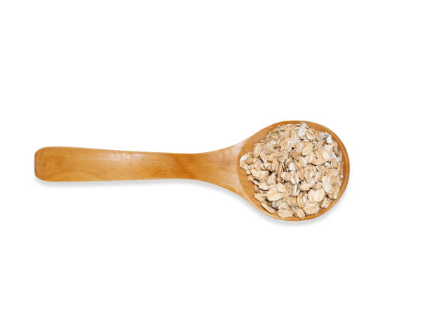 istock Top view  wooden spoon with oatmeal isolated on a white background. 1298356796