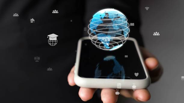 istock Human hand holding mobile phone with earth globe holographic technology 1298357706
