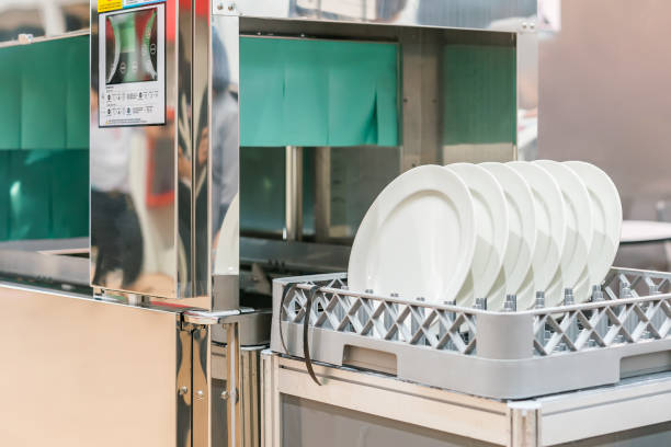 many white plate on basket in automatic dishwasher machine for cleaning in kitchen room restaurant stock photo