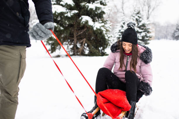 istock A young woman smiling while riding on a sled 1298361671