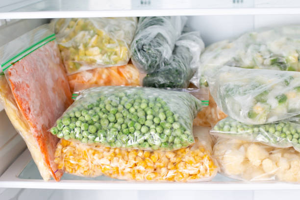 istock Bags with frozen vegetables in refrigerator, closeup 1298361785