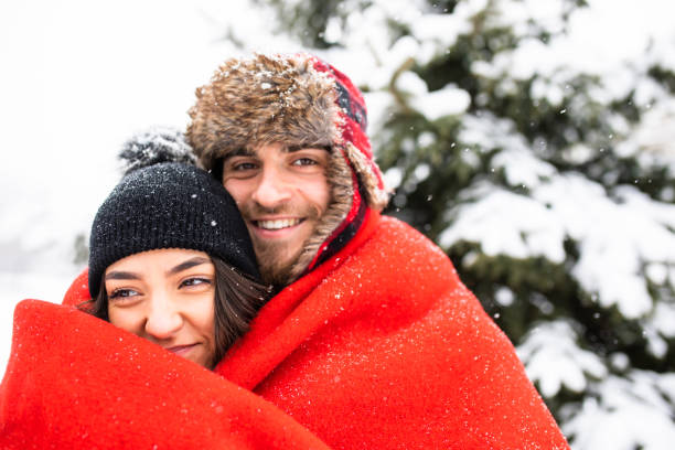 istock An attractive couple under a blanket in snowy mountains 1298362494