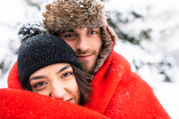 A happy couple snuggled up under a blanket on Valentine's Day