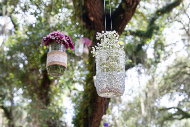 istock Various flowers in mason jars hanging from trees over wedding ceremony 1298363330