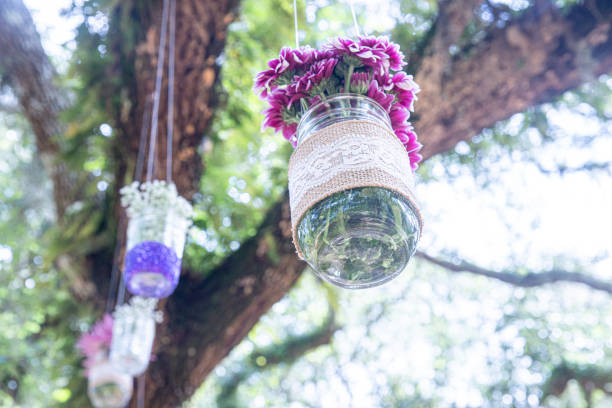 istock Various flowers in mason jars hanging from trees over wedding ceremony 1298363488