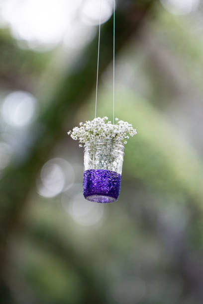 istock Babies breath in clear mason jar with purple bottom hanging from tree over wedding ceremony isle 1298364881