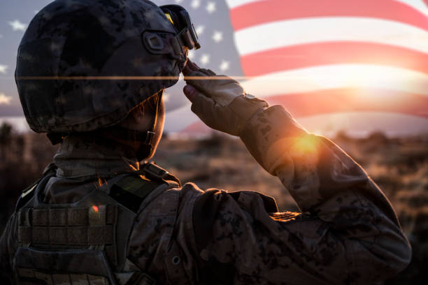 mujer solider saluting bandera de los estados unidos en el amanecer - military fotografías e imágenes de stock