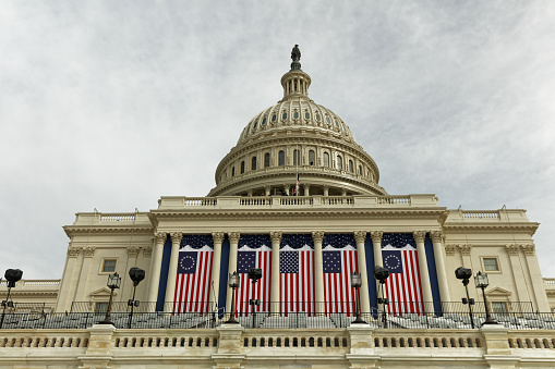 Flags adorn the US Capitol building in Washington DC in preparation for the Inauguration of Joseph Biden and Kamala Harris on January 20, 2021