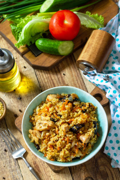 istock Bulgur with turkey and prunes is served with fresh vegetable salad on a rustic table. 1298376030