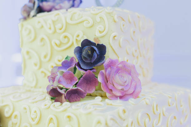 istock White three tier wedding cake with purple flowers decor 1298378584
