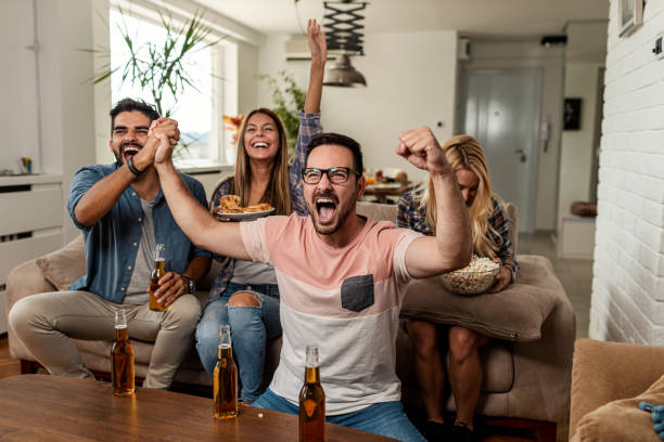 istock Friends watching sport on tv 1298380111