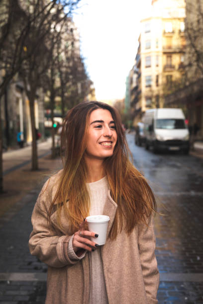 istock Young caucasian woman talking by phone while drinking a coffee in a plastic cup at Donostia-San Sebastian downtown; Basque Country. 1298380215