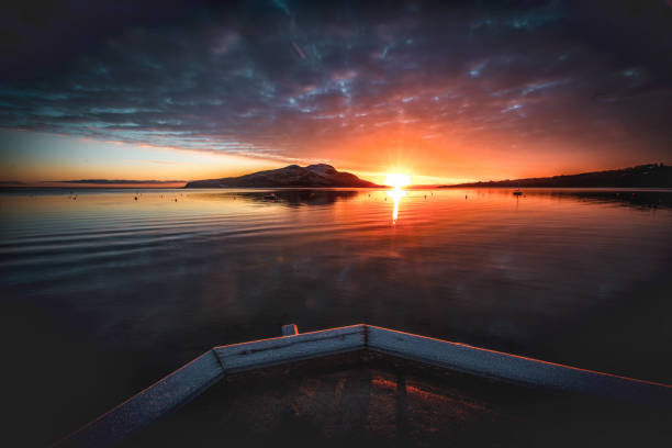 Sunset looking north on the Gastineau Channel near Juneau, AK. Some waves can be seen in the otherwise calm waters of the channel.