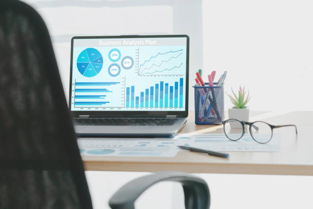 istock Laptop with business financial statistics on a desktop 1298383465