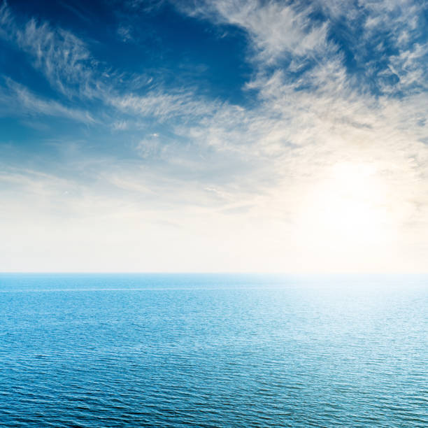 istock low sun in white clouds over blue sea 1298387566
