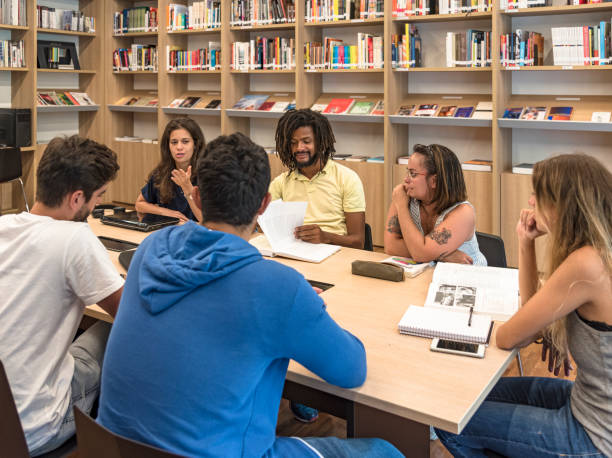 istock Table in library, with young Brazilian university students, studying and debating ideas 1298388973