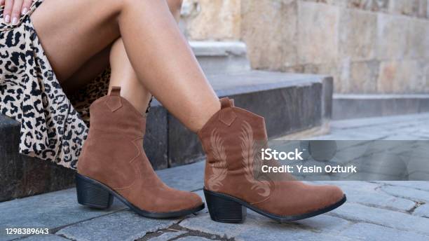 Young Woman In Cowboy Boots Sits On The Street Stock Photo - Download Image Now - Boot, Women, Cowboy Boot