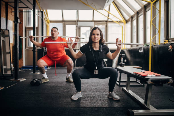 istock Female personal trainer showing her male trainee right way to exercise 1298392040