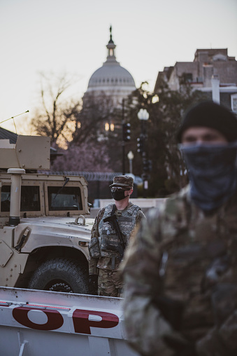Washington DC, USA - January 19, 2021: Members of the Tennessee National Guard stand together at sunset to guard an entrance to Congressional office buildings and the Capitol Building in Washington DC.