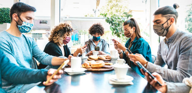 istock People using mobile smart phones at coffee bar - New normal gathering concept about bored friends sharing content online on social media networks - Bright filter with focus on central man 1298393299