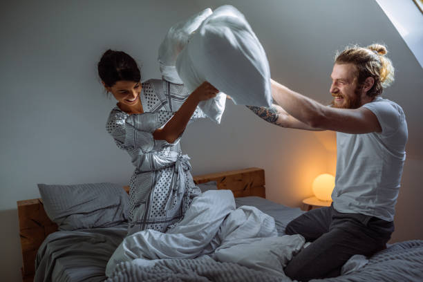 nada nos conecta como compartir cosas en común - bed couple pillow fight men fotografías e imágenes de stock