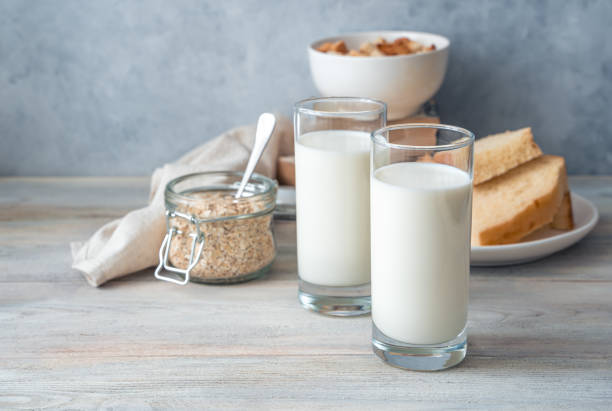 istock Milk in two glasses, bread and oatmeal on a gray background 1298393548