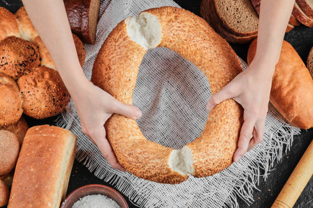 istock Woman holding bagel on dark table with various bread 1298394409
