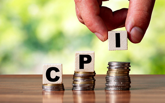 CPI - Customer Price Index word symbol - business concept. Hands put wooden block on stacked increasing coin.