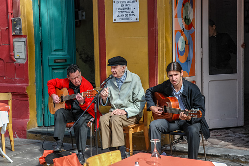 An elderly singer performs for clients of a bar in the Caminito area, in Buenos Aires.