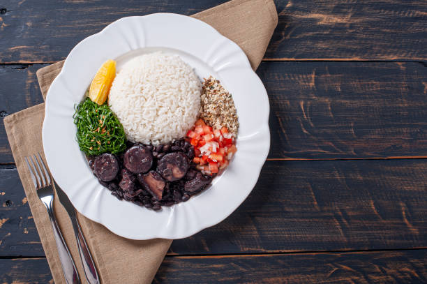 Typical Brazilian dish called Feijoada. Made with black beans, pork and sausage. Top view Typical Brazilian dish called Feijoada. Made with black beans, pork and sausage. Top view beans and rice stock pictures, royalty-free photos & images
