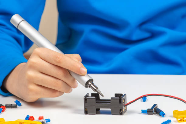 istock Child hands making robot car. Robotic, learning, technology, stem education for children background 1298405369