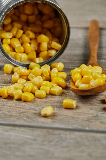 istock A can of boiled sweet corn on a wooden table with a spoon 1298405403