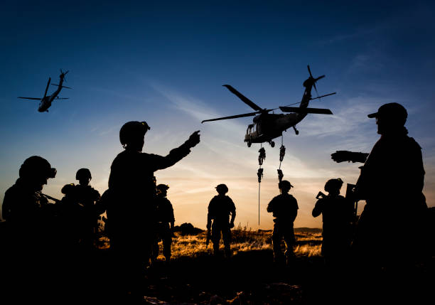 夕暮れ時に軍事ミッションで兵士のシルエット - commando ストックフォトと画像