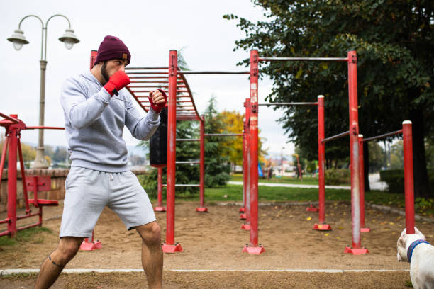 un jeune boxeur ombre boxe à l’extérieur - men sweat combative sport boxing photos et images de collection